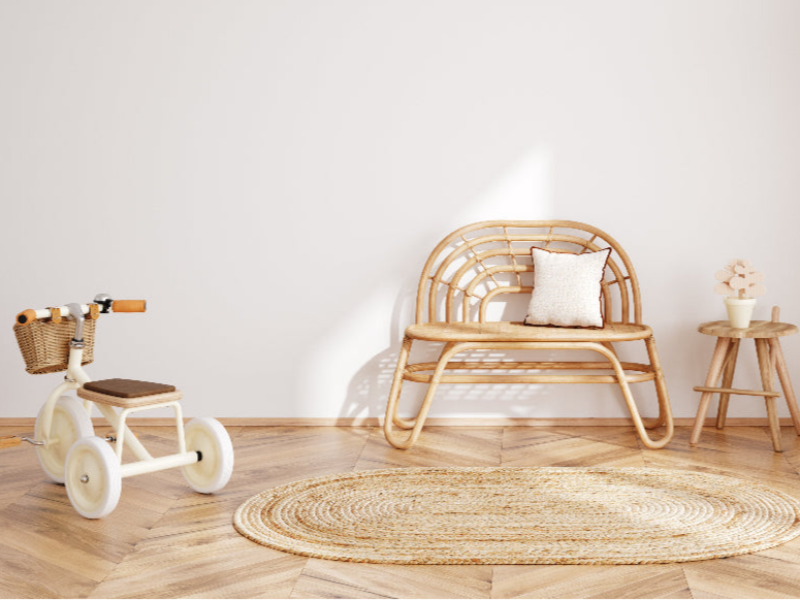 image of a minimalistic room with a white tricycle, a wooden childrens bench and a table